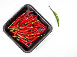 Red chili in black foam tray isolated photo