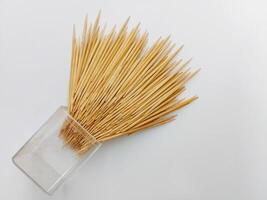 Bundle of Wooden Toothpicks coming out from jar isolated on white background photo