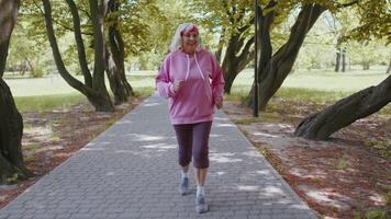 Athletic fitness senior sport runner woman grandmother training workout cardio in park at morning video