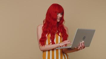 Redhead girl working online on laptop showing thumb up positive good feedback, like, lottery win video