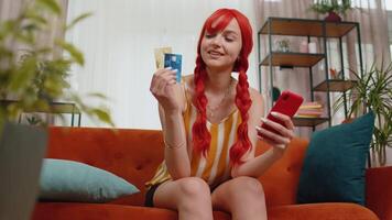 Redhead girl show plastic credit bank card advertising transferring money cashless online shopping video