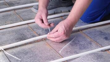 man worker takes measurements during the installation of a warm floor. Warm floor heating system video