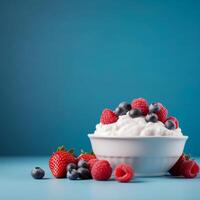 cuenco de yogur con Fresco fresas y arándanos en un azul antecedentes. foto