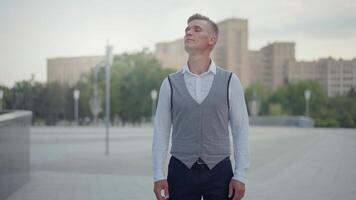 a man in a vest and tie standing in a city video