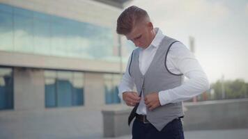 a man in a vest is adjusting his tie video