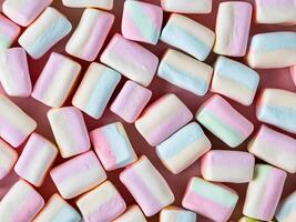 many marshmallows on pastel pink background photo