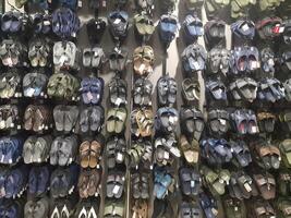 Various types of shoes and sandals displayed in a shoe shop storefront. photo