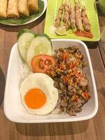 rice bowl, grilled beef belly with spices, served with rice and sunny side up egg. photo