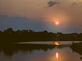 view of the lake in the afternoon with sunset photo