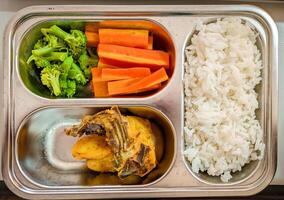 almuerzo caja con arroz, frito pollo y vegetales foto