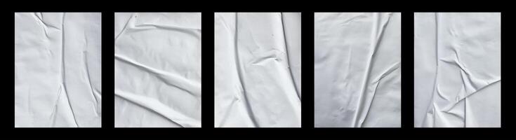 Five white sheets with folds isolated on a black background. photo