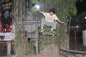 Indonesia - medan 01 agosto 2023 un asiático hombre haciendo patineta trucos en un rampa foto