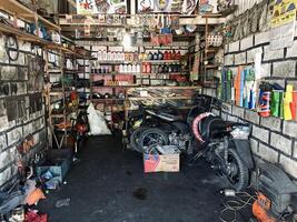 Indonesia - sibolga, 06 abril 2024 motocicleta reparar tienda con de repuesto partes y dañado motos foto