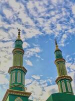 the two towers of a mosque against a blue sky photo