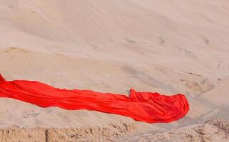 Red fabric podium with sand hill. Promotion layout. Nature, desert. Copy space photo