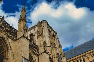 majestuoso gótico catedral fachada en contra un dramático cielo con mullido nubes, exhibiendo intrincado arquitectónico detalles y histórico religioso significado en york, norte yorkshire, Inglaterra. foto