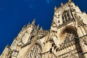 Gothic cathedral facade against a clear blue sky, showcasing intricate architectural details and stone carvings, perfect for historical and travel themes in York, North Yorkshire, England. photo