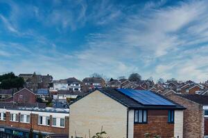 Suburban landscape with residential houses featuring solar panels under a dynamic blue sky with wispy clouds, showcasing sustainable living in a modern neighborhood in Harrogate, North Yorkshire. photo