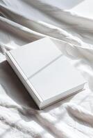 cerrado blanco libro descansando en un limpiar blanco superficie foto