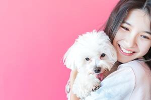 Young Woman Embracing Her Fluffy White Dog Against a Pink Background photo