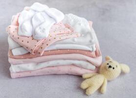 Stack of Baby bodysuits on a grey background. photo