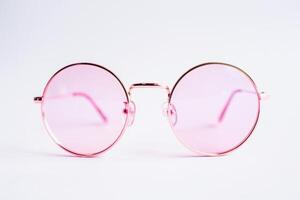 elegante redondo Rosa oro lentes en un suave rosado antecedentes foto