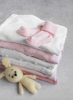 Stack of Baby bodysuits on a grey background. photo