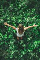 Young Girl Embracing Nature Surrounded by Lush Greenery in Daylight photo