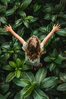 Young Girl Embracing Nature Surrounded by Lush Greenery in Daylight photo