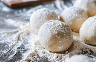 Freshly Made Dough Balls Dusted With Flour on a Wooden Surface photo