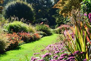 vibrante jardín pasarela bordeado por lozano Camas de flores en un soleado día foto