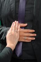 Boda anillo foto disparar concepto un hombre vistiendo un formal negro traje y púrpura Corbata y mujer con púrpura traje es participación un Boda anillo