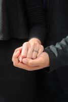 Wedding ring photo shoot concept a man wearing a formal black suit and purple tie and woman with purple suit is holding a wedding ring