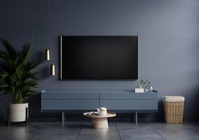 Modern interior of living room with tv on the cabinet on dark blue wall background. photo