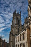 Gothic cathedral against a dramatic sky with fluffy clouds, showcasing intricate architecture and historical grandeur, ideal for travel and cultural themes in York, North Yorkshire, England. photo