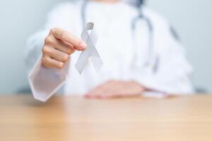 Brain Cancer Awareness May month, Doctor with grey color Ribbon for supporting life people. Healthcare and World cancer day concept photo