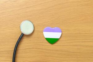 Queer Pride Day and LGBT pride month concept. purple, white and green heart shape with Stethoscope for Lesbian, Gay, Bisexual, Transgender, genderqueer and Pansexual community photo