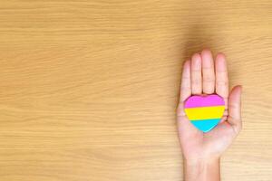 Pansexual Pride Day and LGBT pride month concept. hand holding pink, yellow and blue heart shape for Lesbian, Gay, Bisexual, Transgender, Queer and Pansexual community photo