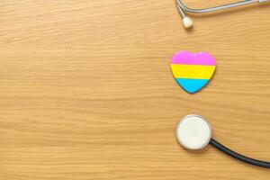 Pansexual Pride Day and LGBT pride month concept. pink, yellow and blue heart shape with Stethoscope for Lesbian, Gay, Bisexual, Transgender, Queer and Pansexual community photo