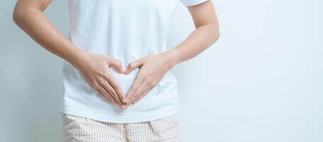 Woman hand heart shape over abdomen. Ovarian and Cervical cancer, Endometriosis, Hysterectomy, Uterine fibroids, Reproductive, menstruation, Stomach, Pregnancy and Sexual Transmitted disease concept photo