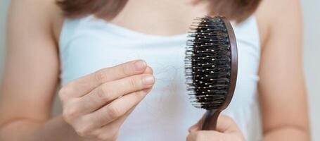 pelo pérdida problema, que se está quedando calvo , belleza tratos y salud cuidado conceptos asiático mujer participación participación peine con pelo pérdida, joven hembra sostener cepillo para el pelo y cepillado con otoño pelo desde cuero cabelludo foto