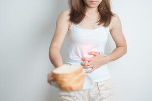 Gluten intolerance, Gluten free and celiac disease or wheat allergy concept. woman hold Bread and having abdominal pain after eat gluten. stomach ache, Nausea, Bloating, Gas, Diarrhea and Skin rash photo