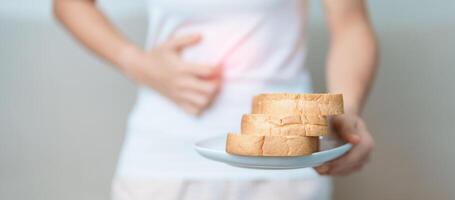 Gluten intolerance, Gluten free and celiac disease or wheat allergy concept. woman hold Bread and having abdominal pain after eat gluten. stomach ache, Nausea, Bloating, Gas, Diarrhea and Skin rash photo