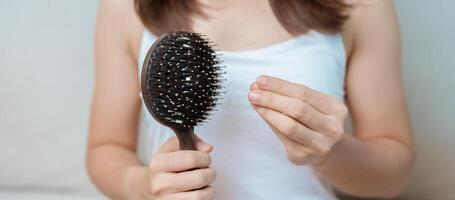 pelo pérdida problema, que se está quedando calvo , belleza tratos y salud cuidado conceptos asiático mujer participación participación peine con pelo pérdida, joven hembra sostener cepillo para el pelo y cepillado con otoño pelo desde cuero cabelludo foto