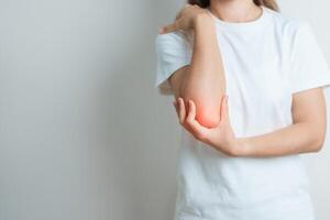 Woman having elbow ache at home, muscle pain due to lateral epicondylitis or tennis elbow. injury, Health and medical concept photo