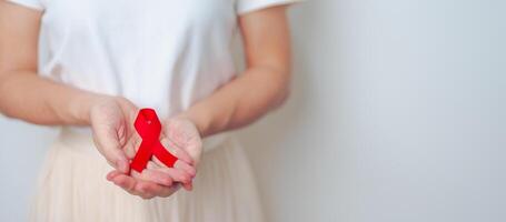 woman with Red Ribbon for December World Aids Day, acquired immune deficiency syndrome, multiple myeloma Cancer Awareness month and National Red ribbon week. Healthcare and world cancer day concept photo