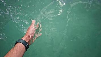 Male Hand with black modern Smartwatch splashing turquoise Water on Lake. Close up of man's Palm hitting Water Surface in Slow Motion and making huge Splash video