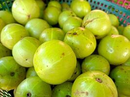 Indian gooseberry in the basket on a wooden floor photo