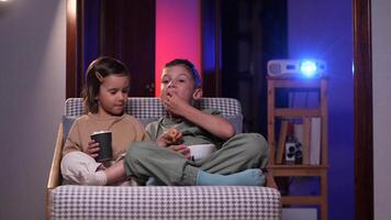 brother and sister laughing and watching funny movie in home theater video