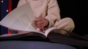 de cerca de un pequeño niña hojeando mediante un libro con hada cuentos video